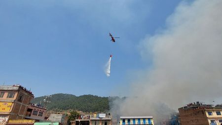 तनहुँको दमौलीमा हेलिकप्टर प्रयोग गरेर आगो निभाईदै